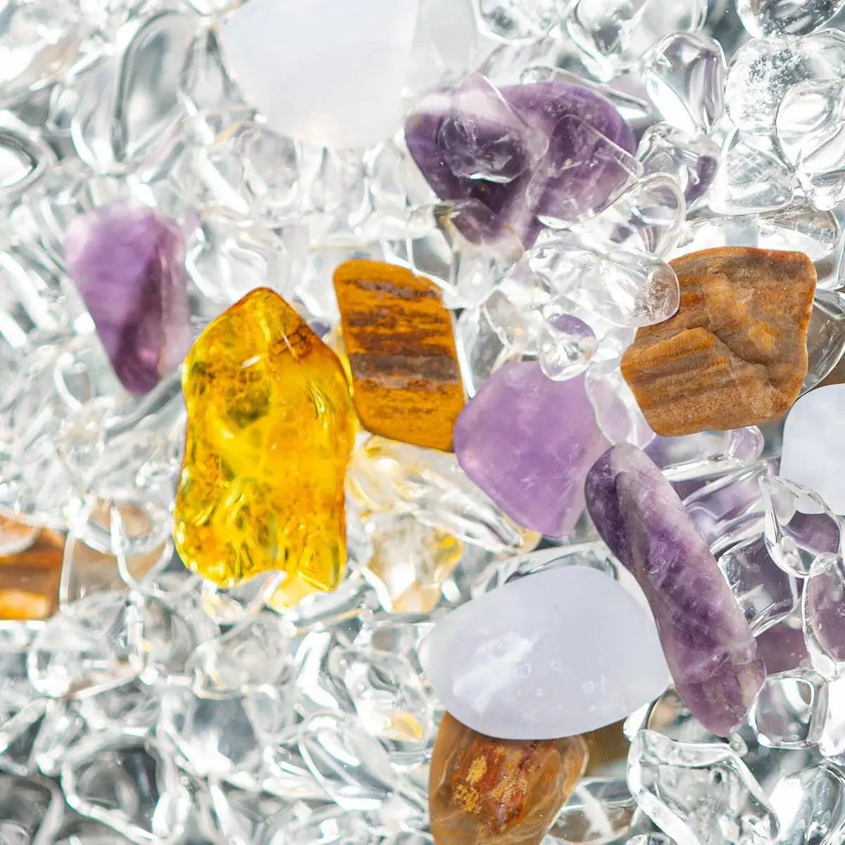 Mélange de pierres naturelles polies dont quartz rose, améthyste et cristal de roche pour synergie énergétique Triangle d’Or