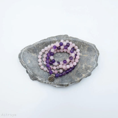 Mala Bouddha en quartz rose et améthyste | 108 perles - sur un marbre gris
