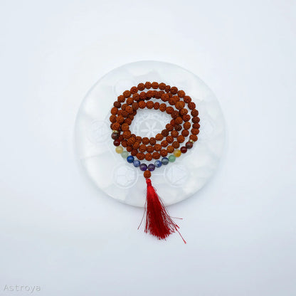 Mala Rudraksha 7 chakras sur une pierre de chargement en sélénite