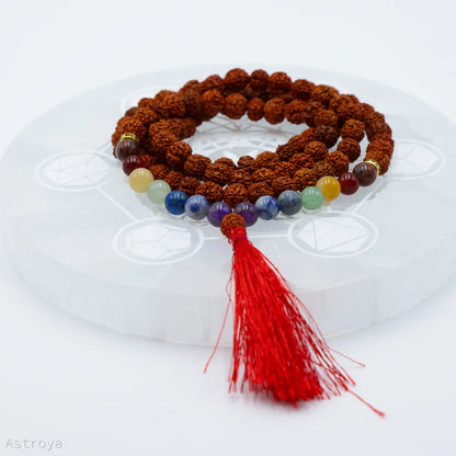 Vue détaillée du Mala Rudraksha 7 chakras sur une pierre de chargement en sélénite