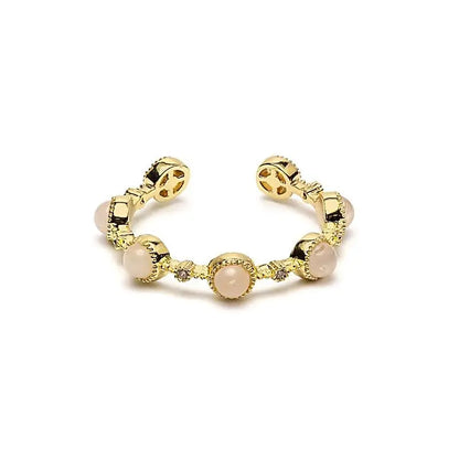 Détail de la bague ouverte quartz rose sur doigt féminin bijou élégant et minimaliste