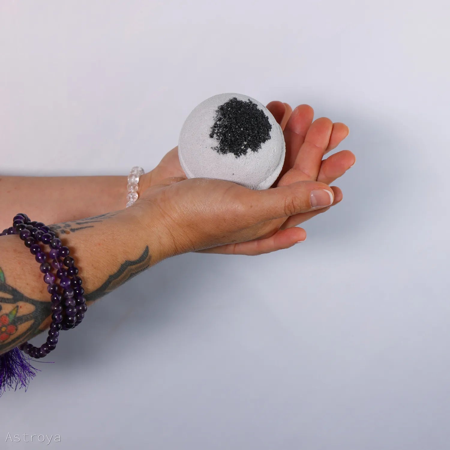 Bombe de bain au charbon tenue dans une main