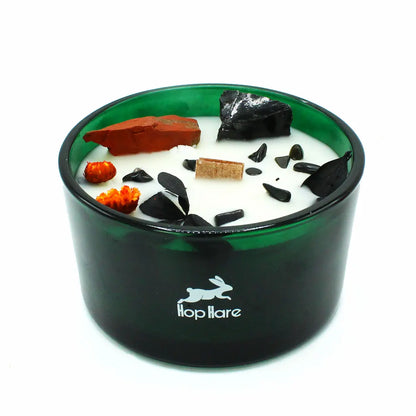 Gros plan bougie Le Diable parfum brasier en pleine floraison avec pierres de jaspe rouge et agate noire