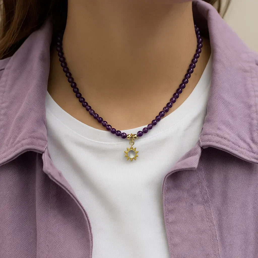 Collier améthyste avec pendentif soleil porté autour du cou