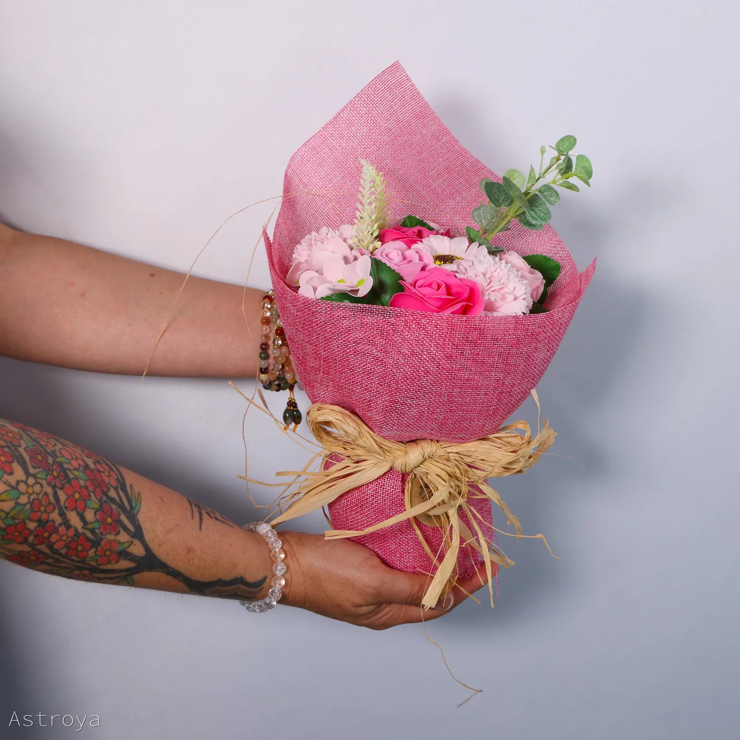 Bouquet de fleurs de savon couleur rose présenté par une femme