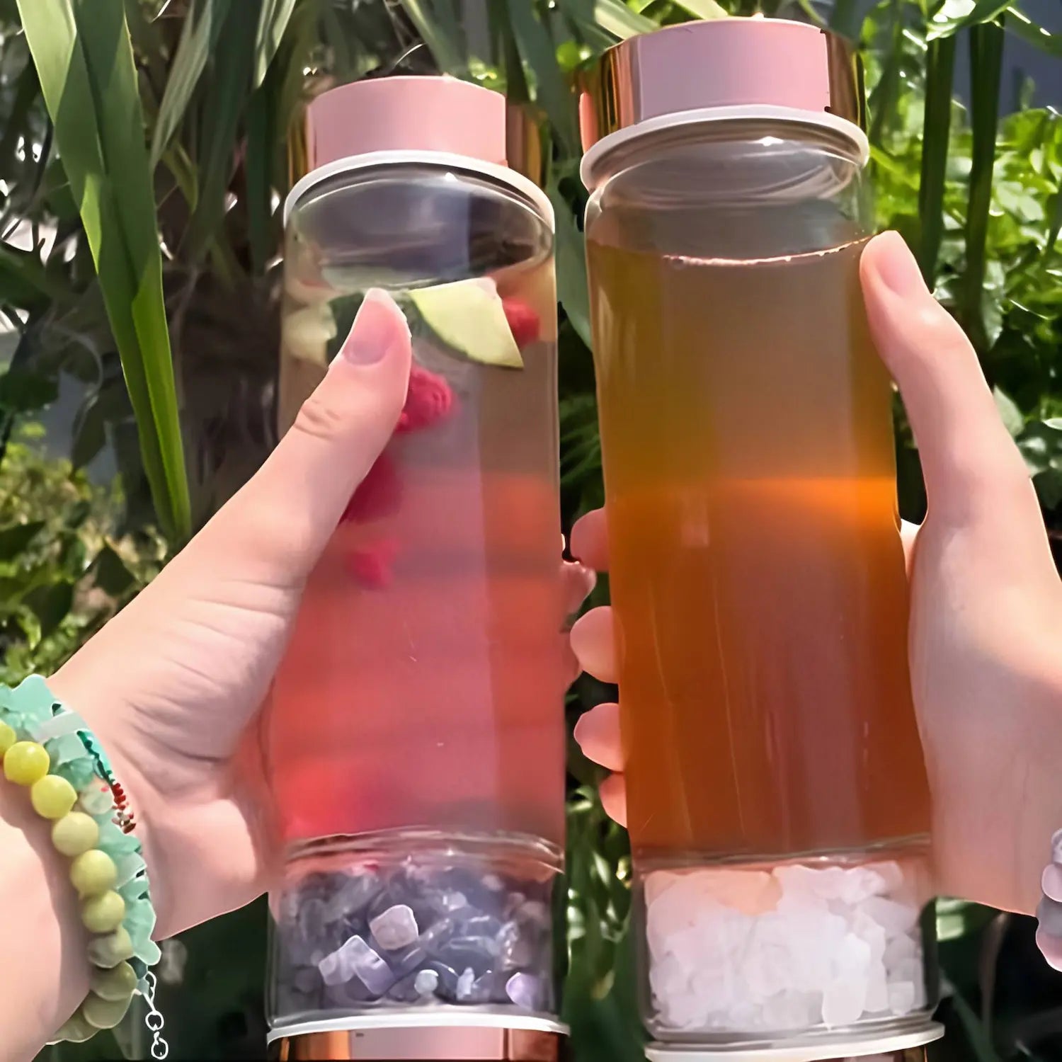 Deux gourdes infuseurs quartz rose remplies, l’un avec du thé chaud et l’autre avec une infusion de fruits frais colorés