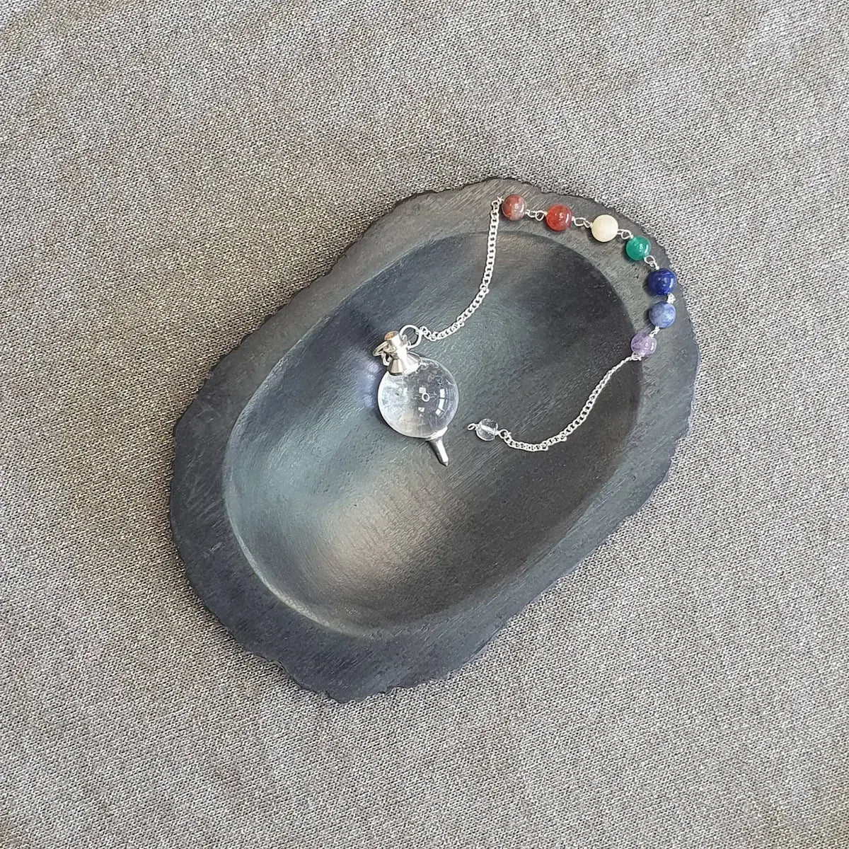 Le Pendule 7 chakras sur une plaque de marbre véritable